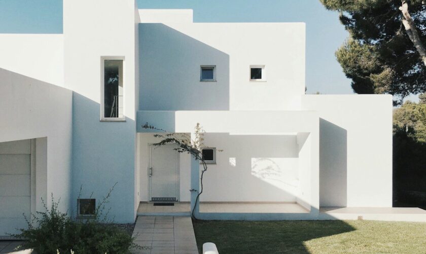 white concrete house near green tree during daytime