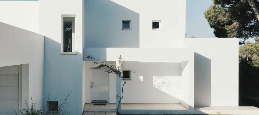 white concrete house near green tree during daytime