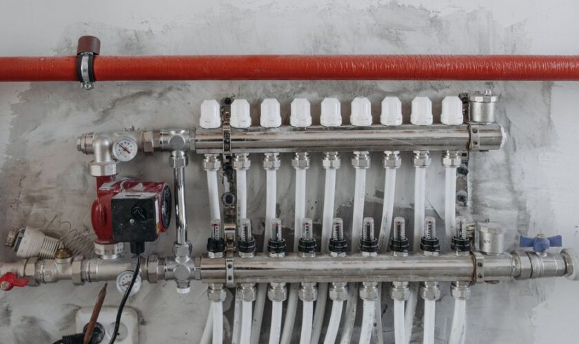 A close-up view of an industrial manifold with pressure gauges and connected steel pipes.