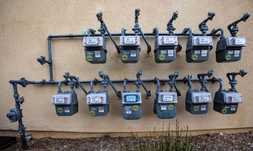 A neat installation of gas meters mounted on an exterior wall in an urban setting.