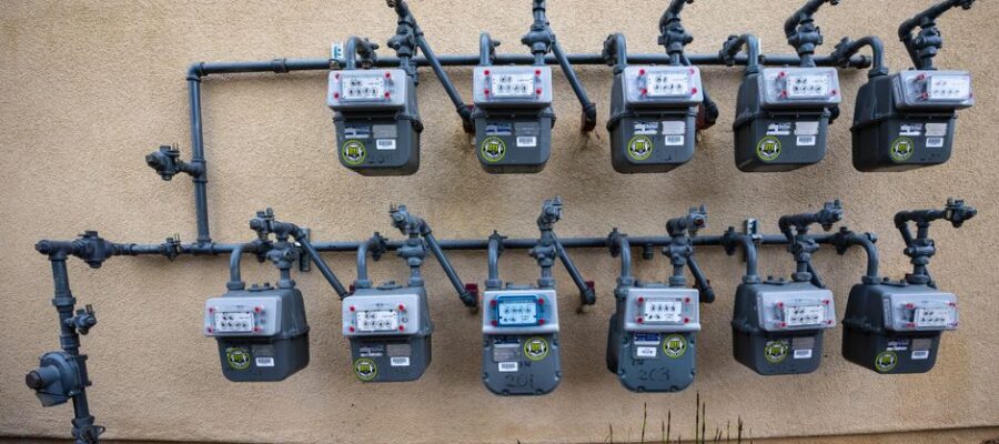 A neat installation of gas meters mounted on an exterior wall in an urban setting.