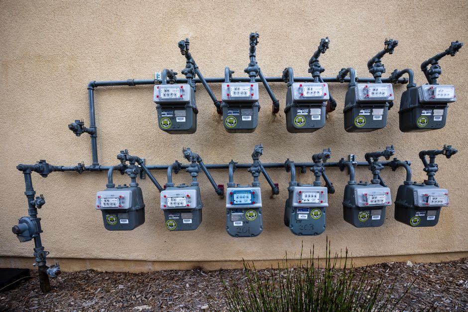 A neat installation of gas meters mounted on an exterior wall in an urban setting.