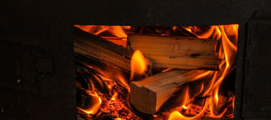 A warm and cozy view of firewood burning in a stove, highlighting the natural flames.