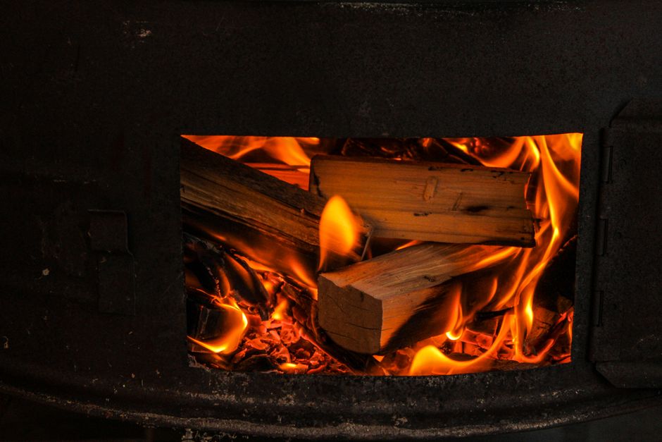 A warm and cozy view of firewood burning in a stove, highlighting the natural flames.