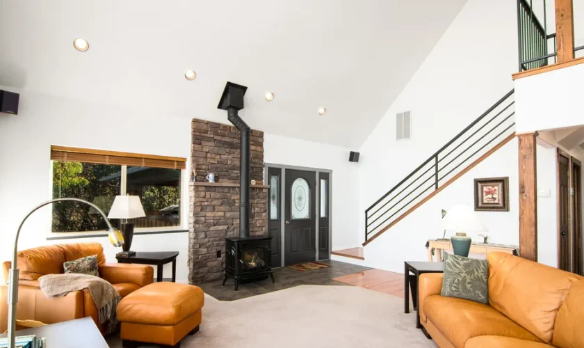Bright and welcoming living room featuring a rustic fireplace and modern decor.