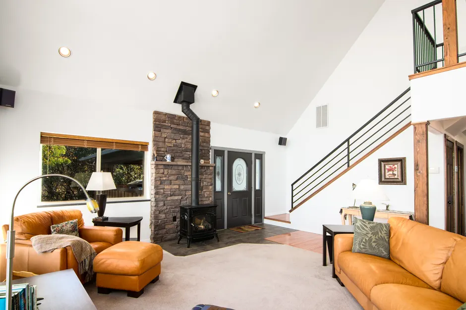 Bright and welcoming living room featuring a rustic fireplace and modern decor.