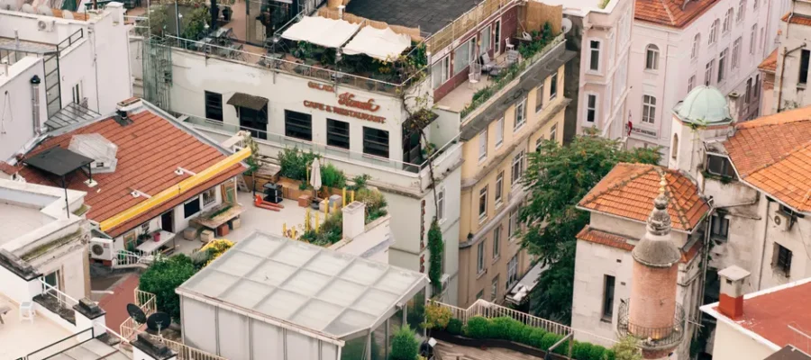 Captivating aerial shot of urban European rooftop gardens and architecture with terracotta roofs.