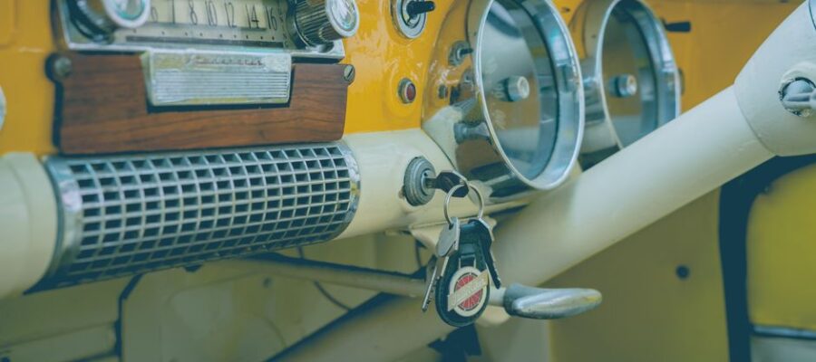 Close-up of a classic vintage car dashboard featuring an analog radio, speedometer, and keys.