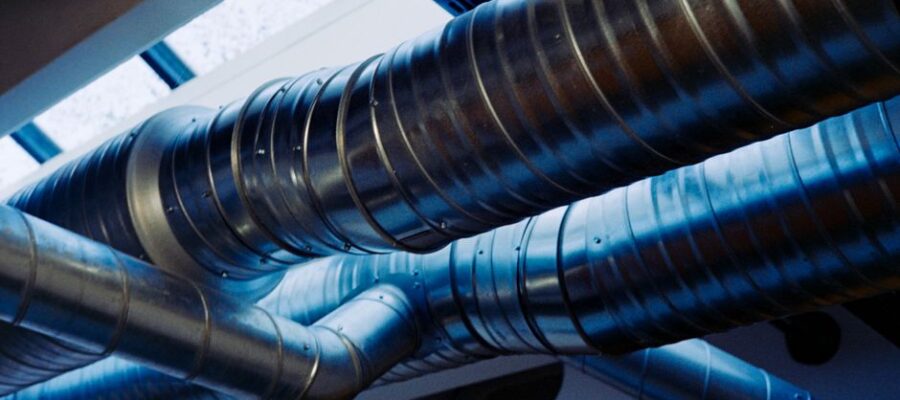 Close-up of a modern metallic ventilation system in an industrial setting.