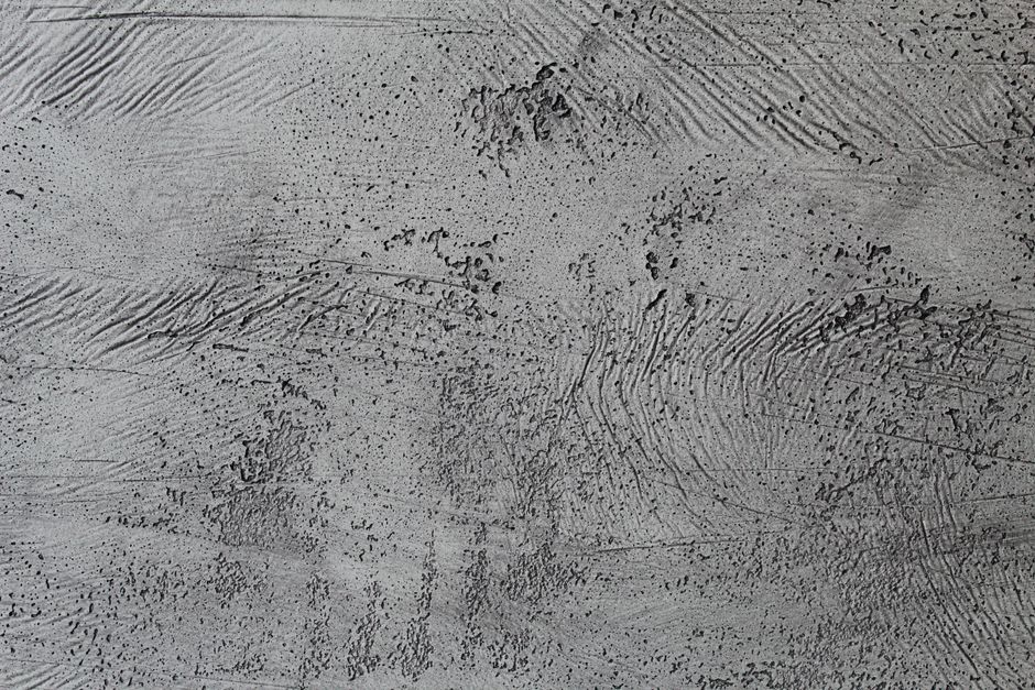 Close-up of a rough gray concrete wall surface showcasing unique patterns and textures.