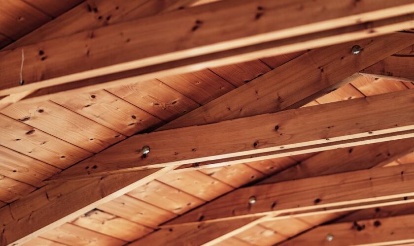 Close-up of a rustic wooden ceiling with exposed beams and natural wood texture.