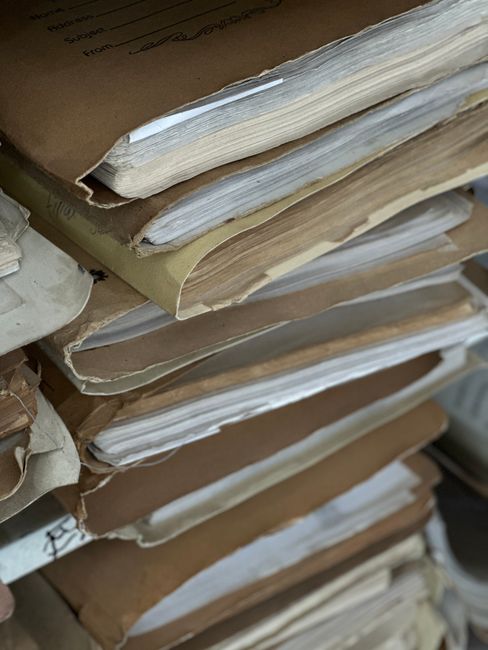 Close-up of old paper files stacked in vintage brown folders, organized and archived.