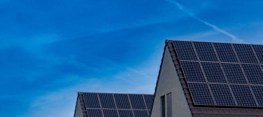 Contemporary homes featuring solar panels under a bright blue sky promoting renewable energy.