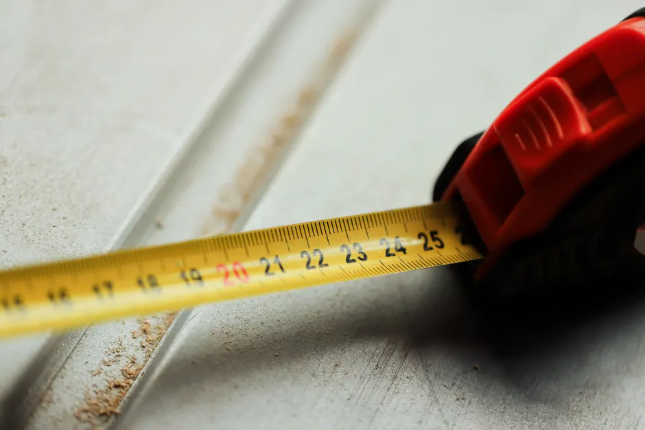 Detailed view of a tape measure on a construction surface, highlighting measurement accuracy.