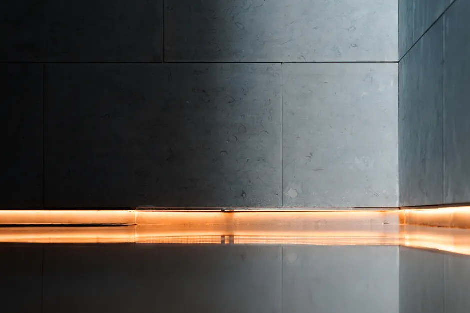 Modern interior showcasing sleek walls, reflective flooring, and ambient lighting for a serene atmosphere.