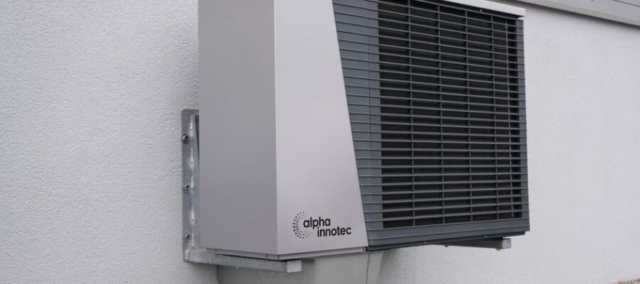 Outdoor air conditioning unit mounted on a residential building exterior.