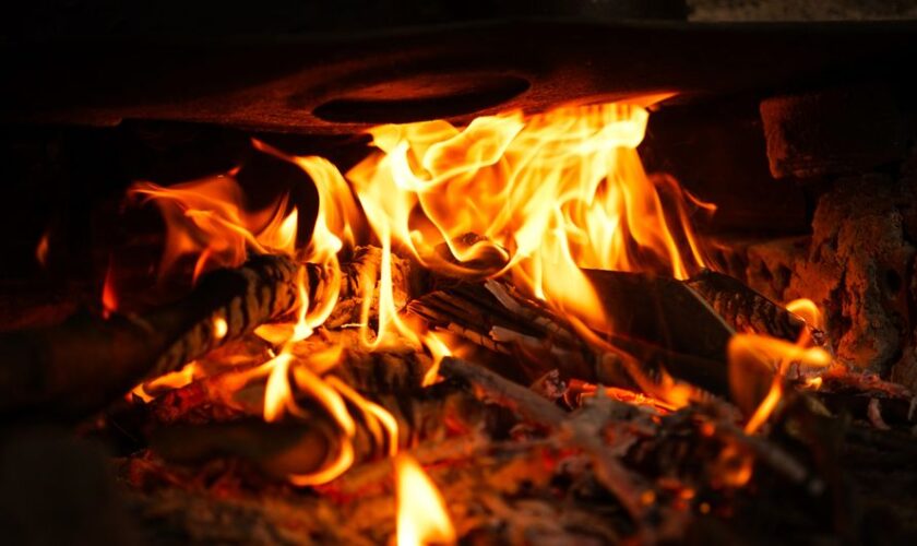 A close-up of vibrant flames engulfing wood, showcasing the warmth and energy of fire.