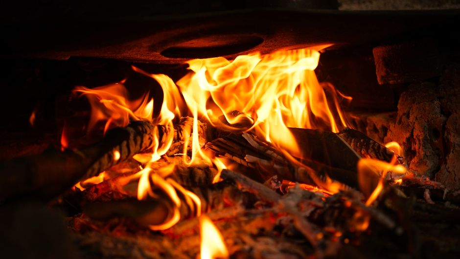 A close-up of vibrant flames engulfing wood, showcasing the warmth and energy of fire.