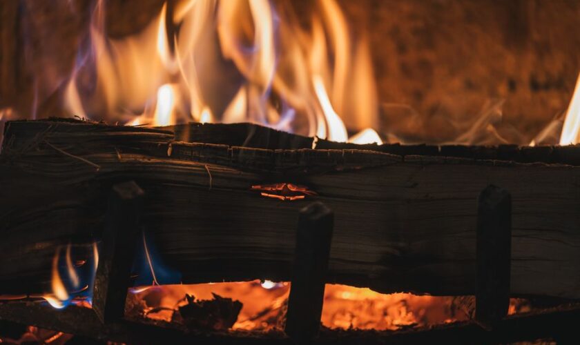 A close-up view of a cozy fireplace with burning firewood and vivid flames.