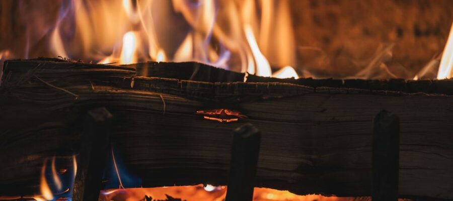A close-up view of a cozy fireplace with burning firewood and vivid flames.
