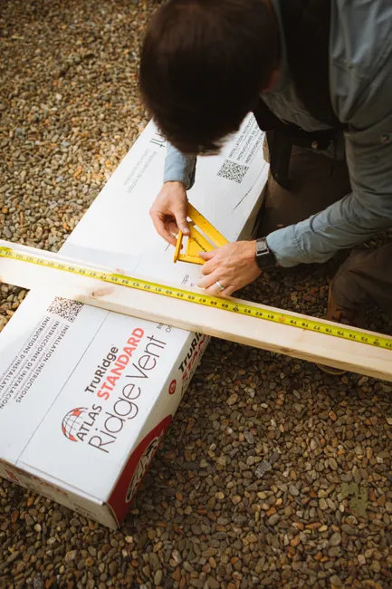 A construction worker measures wood for roof installation in Cashiers, North Carolina.