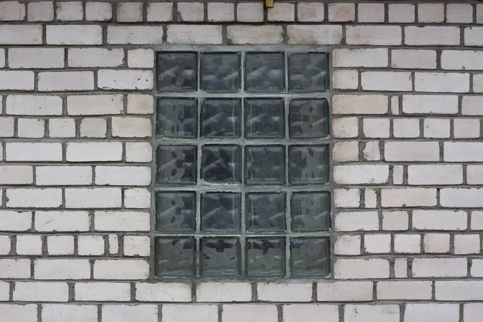 A glass block window set in a white brick wall offers a modern architectural detail.