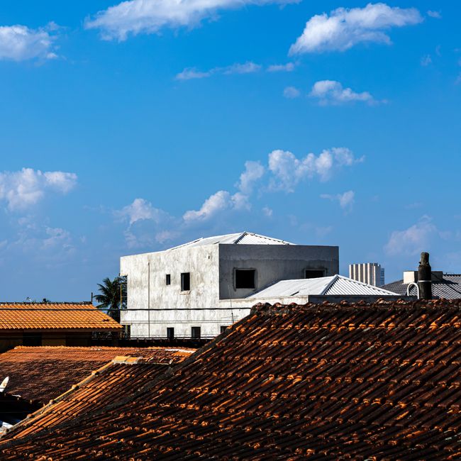 A vibrant view of urban rooftops under a clear blue sky. Perfect for architecture and cityscape concepts.