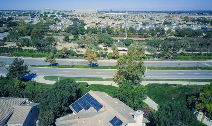 Aerial view showing suburban houses with solar panels, showcasing clean energy.