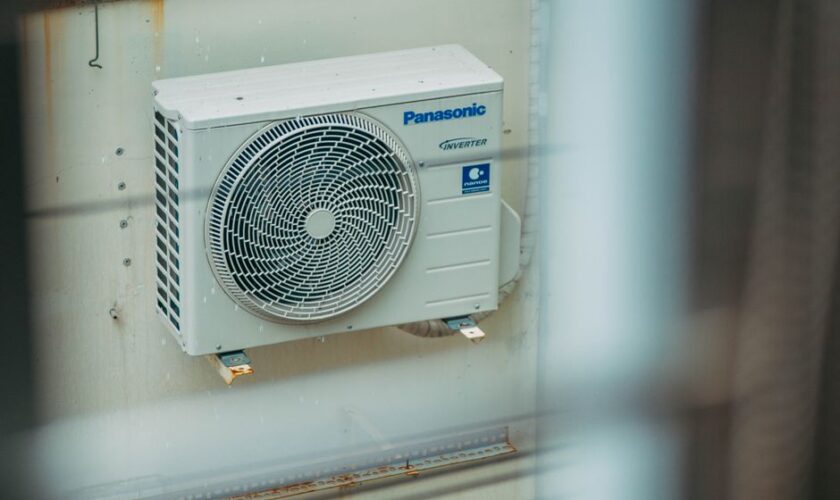 Air conditioner unit mounted outdoors on a building wall, showcasing modern HVAC technology.