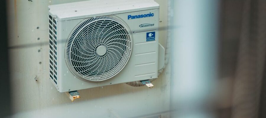 Air conditioner unit mounted outdoors on a building wall, showcasing modern HVAC technology.