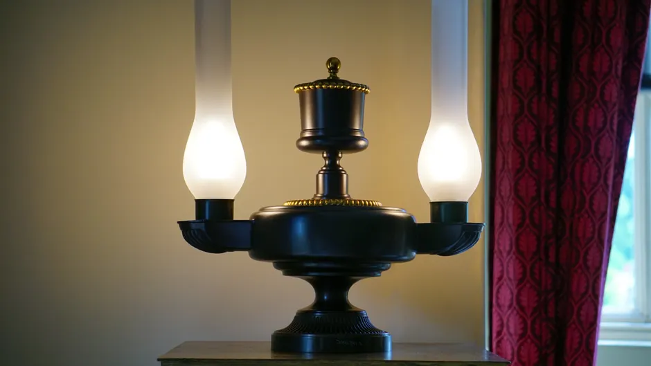 Antique table lamp with glowing bulbs in a classic home interior, creating a warm atmosphere.