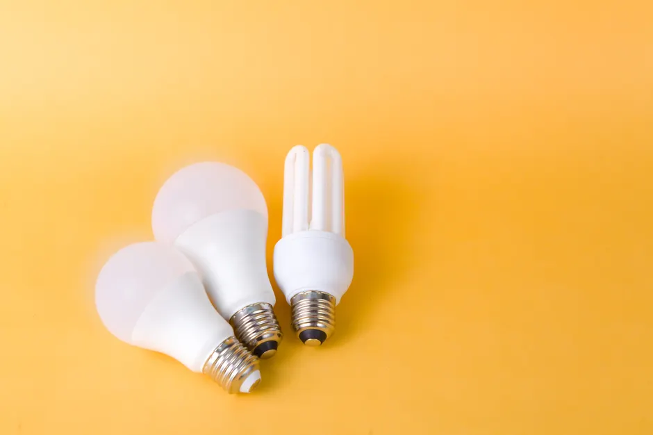 Bright and efficient LED and CFL bulbs on vibrant yellow backdrop.