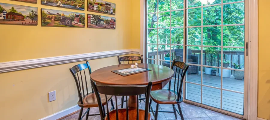 Charming dining area with paintings, table, and sliding door opening to a balcony.