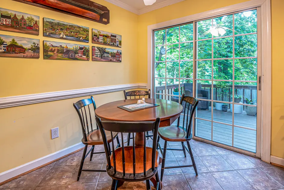 Charming dining area with paintings, table, and sliding door opening to a balcony.