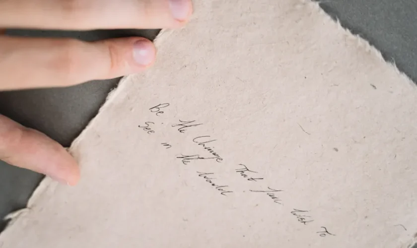 Close-up of a handwritten inspirational quote on textured paper.