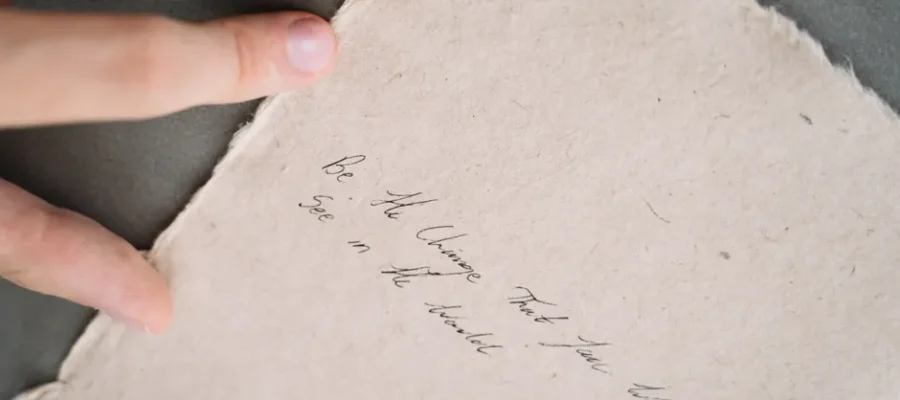 Close-up of a handwritten inspirational quote on textured paper.