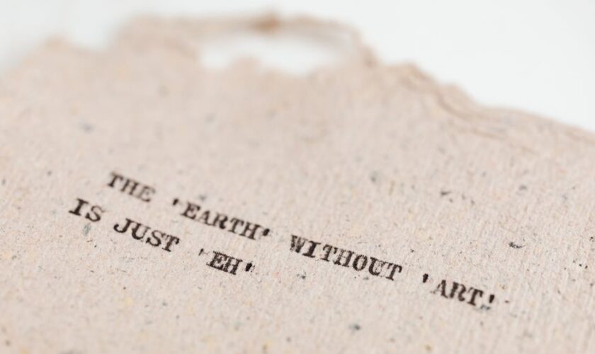 Close-up of a motivational art quote on a handmade textured paper background.