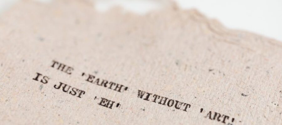 Close-up of a motivational art quote on a handmade textured paper background.