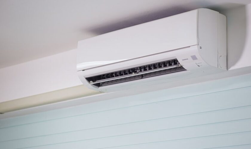 Close-up of a wall-mounted air conditioner indoors, showcasing sleek design for modern cooling solutions.