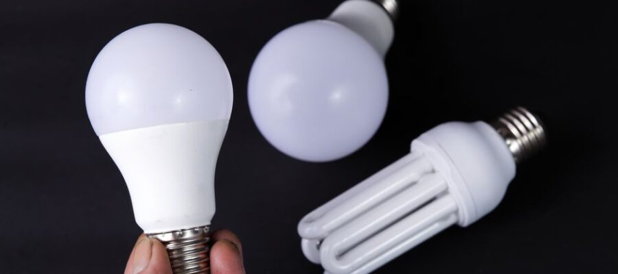 Close-up of energy-efficient LED and CFL light bulbs on a black surface.