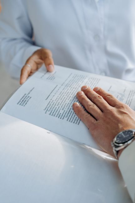 Close-up of hands reviewing a business agreement document. Professional setting.