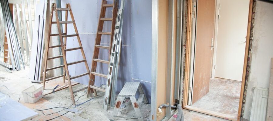 Construction site featuring ladders and tools in a home renovation setting.