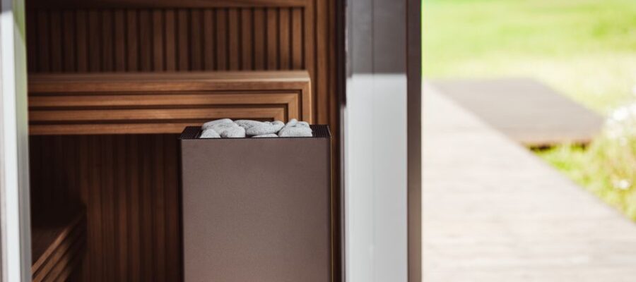 Contemporary outdoor sauna featuring wood panels and an electric heater with stones.