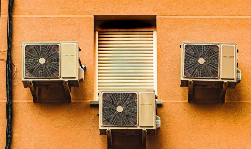 Exterior wall with three air conditioners, showcasing modern architectural elements.