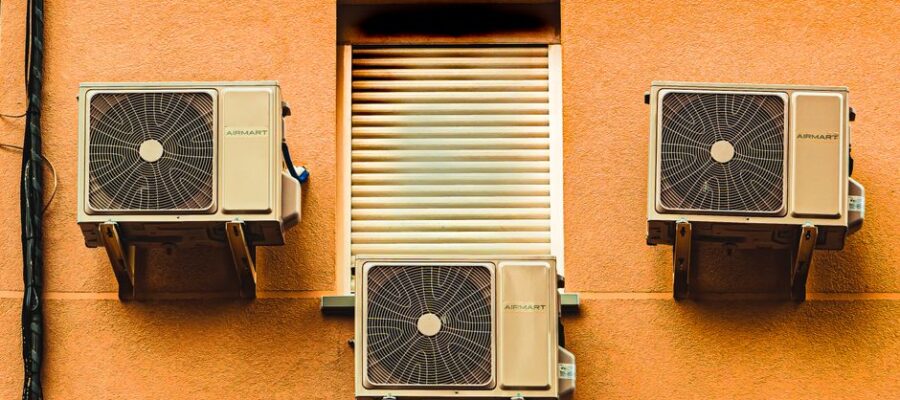 Exterior wall with three air conditioners, showcasing modern architectural elements.