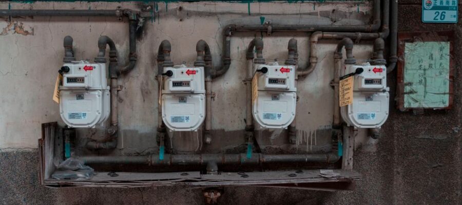 Four gas meters mounted on an exterior wall, showcasing urban utility infrastructure.
