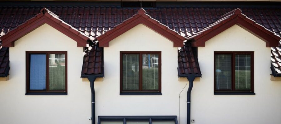 Front view of a modern house with a red tiled roof and multiple windows.