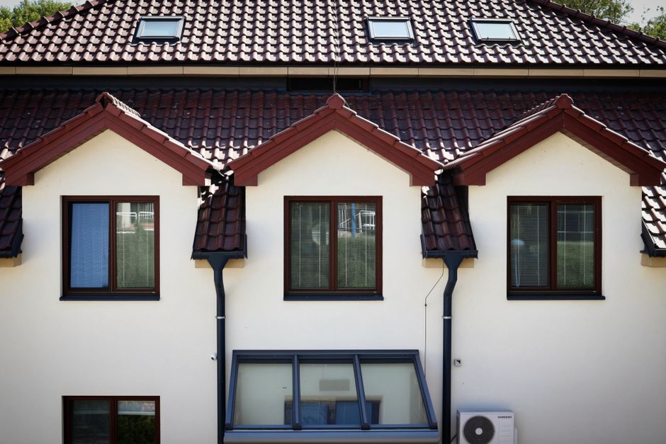 Front view of a modern house with a red tiled roof and multiple windows.