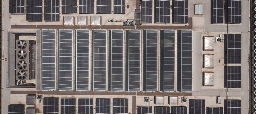 High-angle drone shot of rooftop solar panels showcasing renewable energy technology.