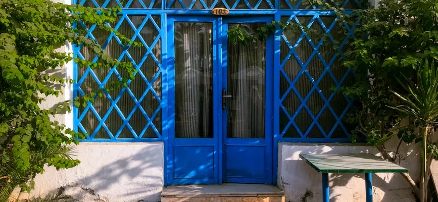 Inviting blue lattice door surrounded by greenery, capturing Egyptian urban charm.